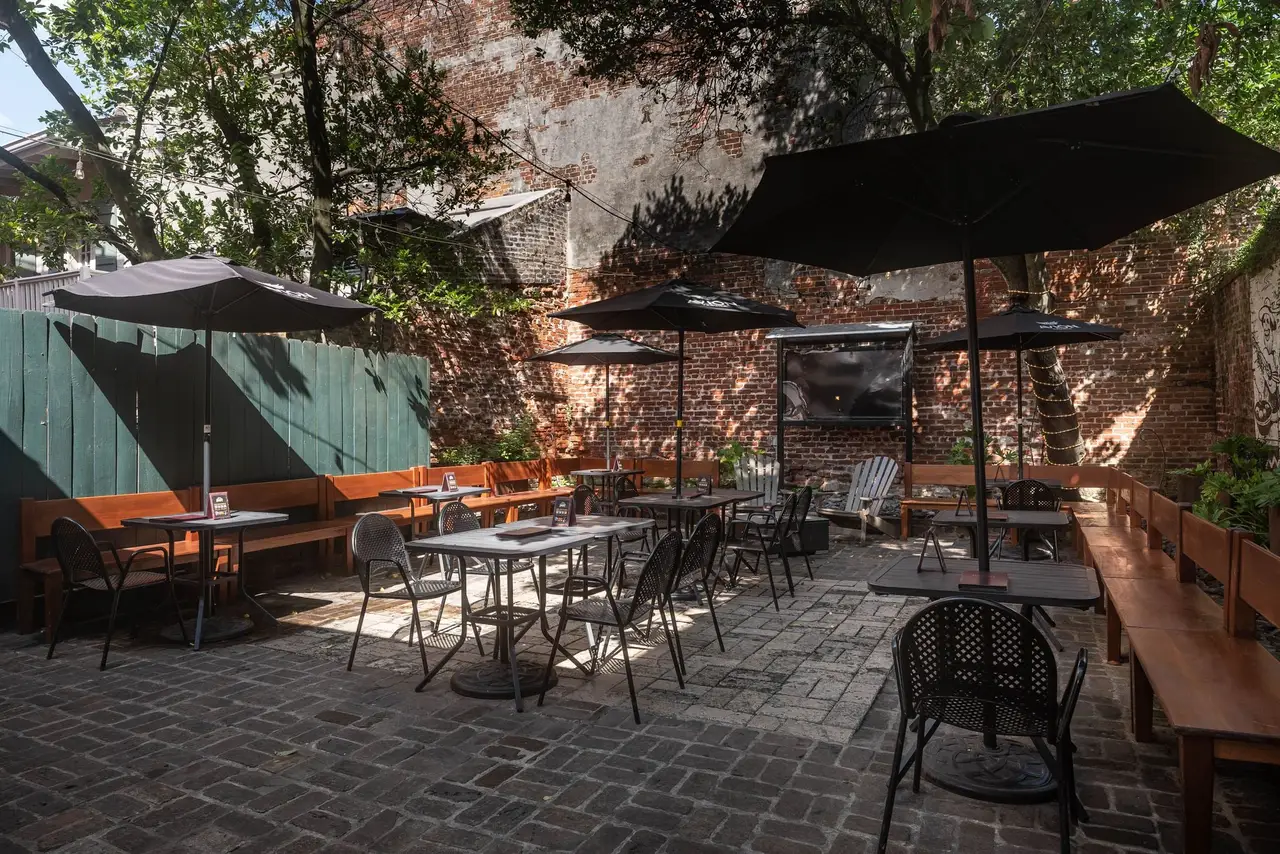 Bistro tables, benches and umbrellas on the brick pavers of the courtyard